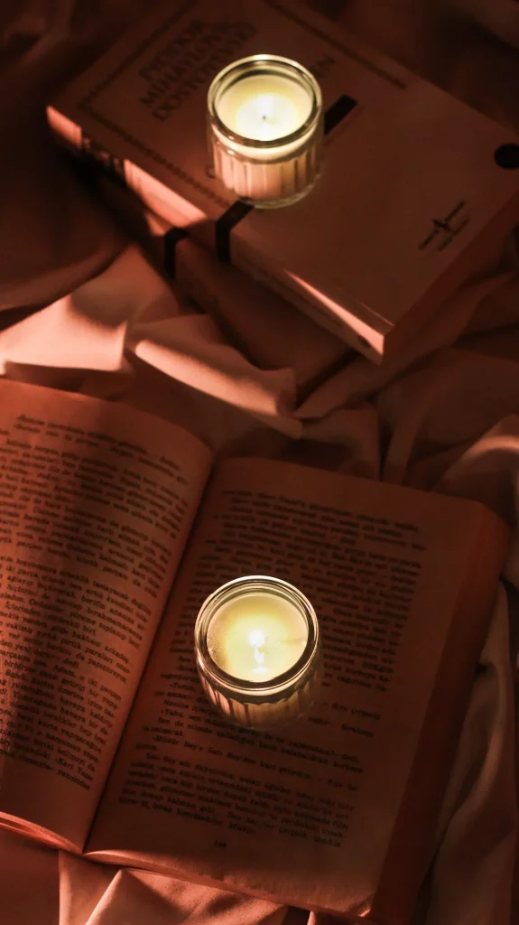 Livres ouverts éclairés par des bougies, ambiance cosy pour la lecture du soir